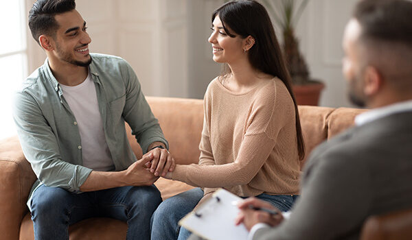 happy-couple-talking-at-therapy Premarital Counseling